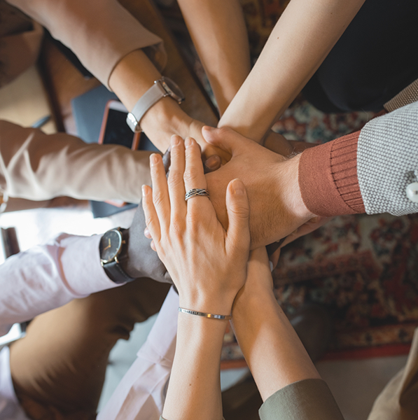 Group of people in circle putting hands together