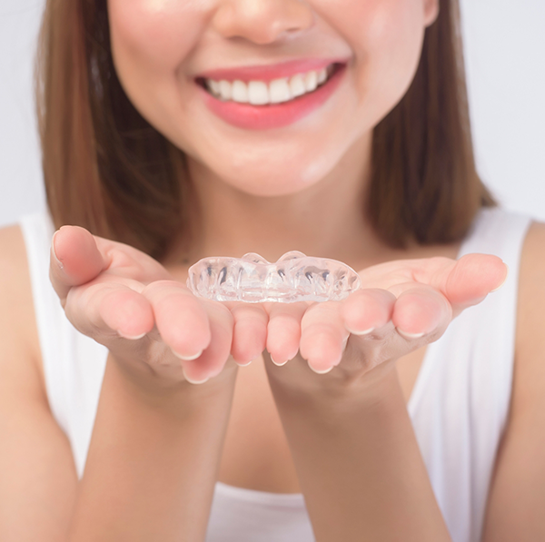 Close up of woman holding clear aligner